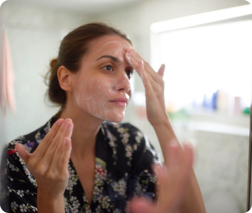 femme appliquant de la crème sur son visage