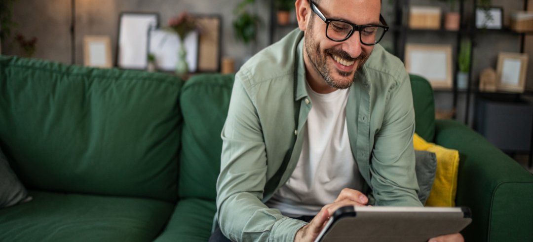 Homme souriant devant sa tablette