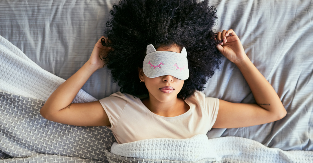 Femme allongée dans son lit avec un masque sur les yeux